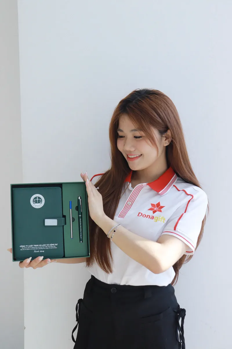 Nhân viên DonaGift giới thiệu bộ quà tặng sổ và bút in logo